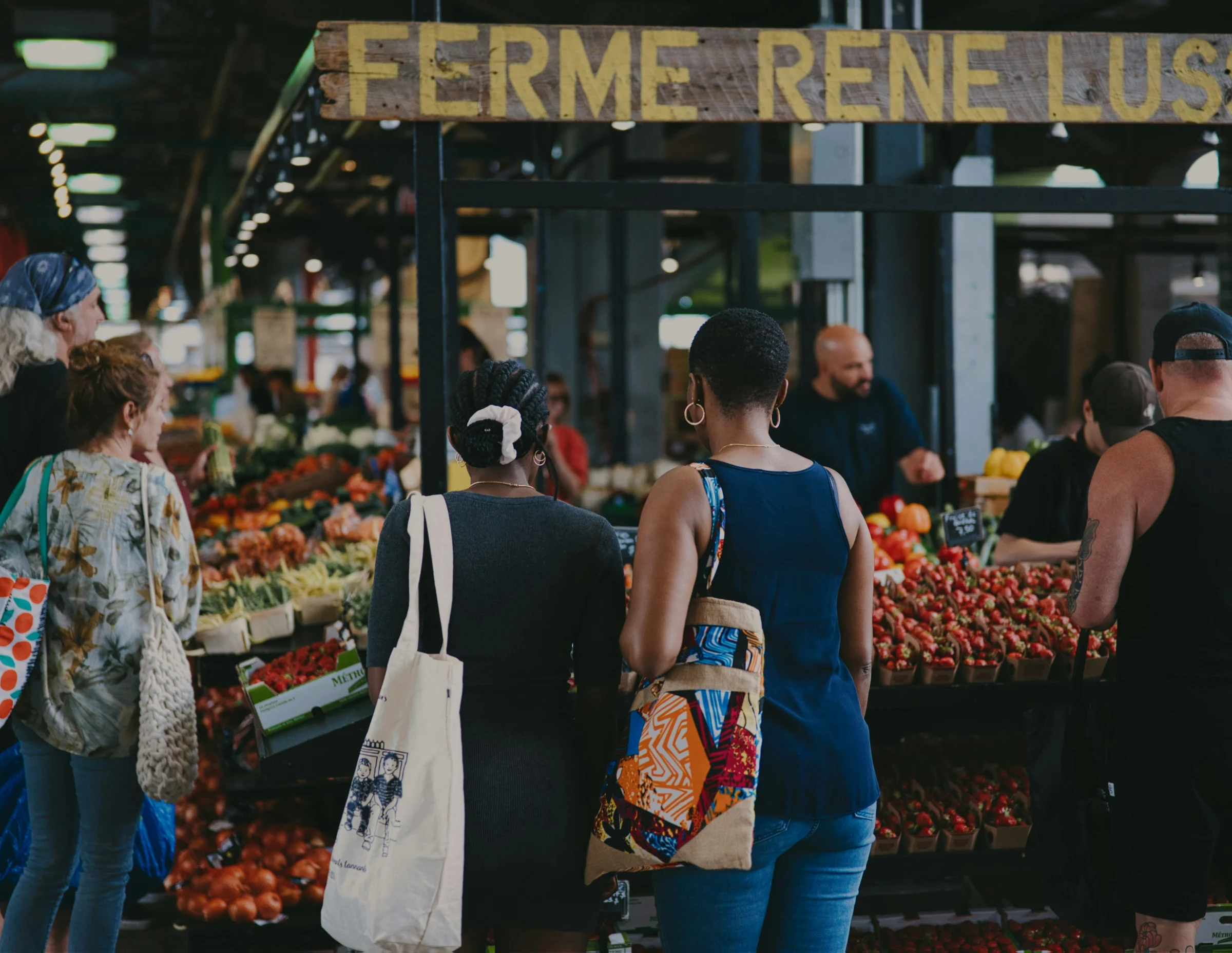Visiteurs circulant entre les étals d’un marché de producteurs.