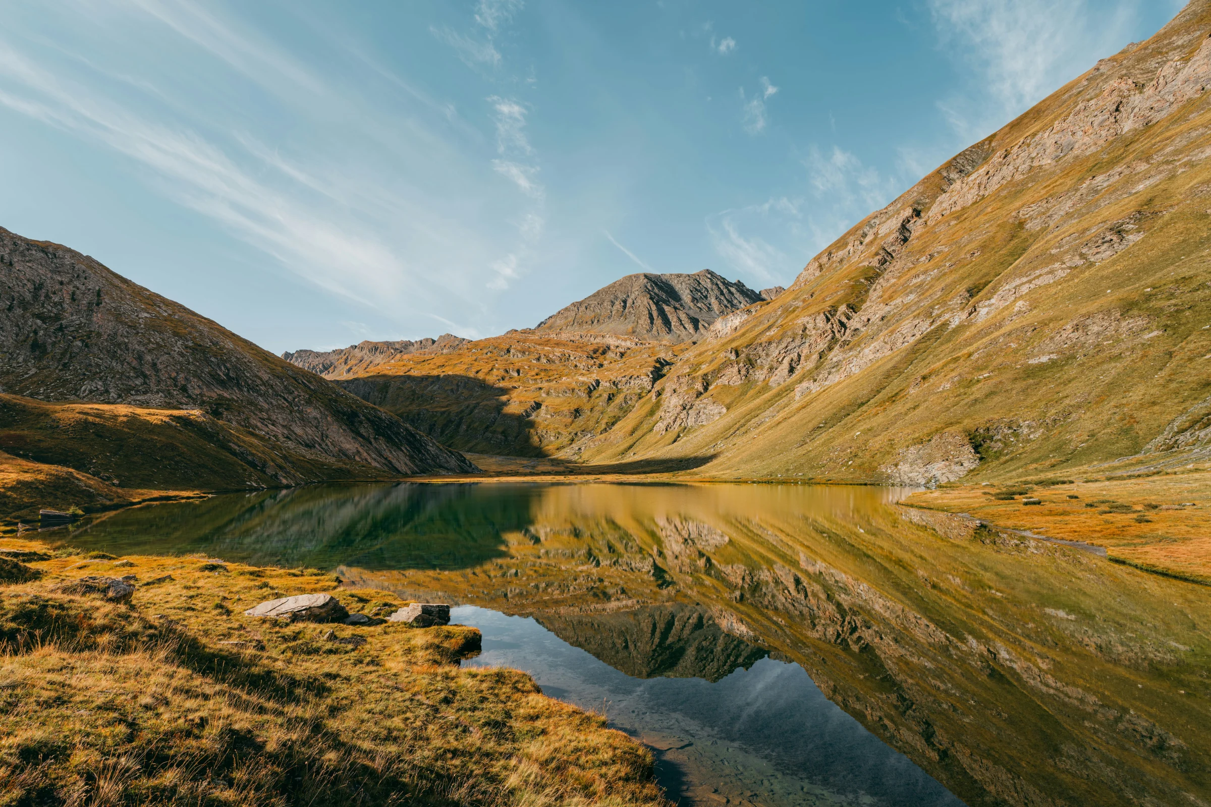 Lac Égorgéou entouré de montagnes et de végétation aux couleurs d’automne dans le Queyras, Hautes-Alpes.